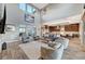 Bright open-plan living room with high ceilings, modern furniture, and seamless flow into the kitchen at 6800 Equinox Cliff St, Las Vegas, NV 89135