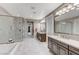 Luxurious bathroom featuring dual vanities, a glass-enclosed shower, a soaking tub, and marble accents at 6800 Equinox Cliff St, Las Vegas, NV 89135