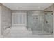 Beautiful bathroom with a soaking tub, glass shower enclosure, window shutters, and marble tile at 6800 Equinox Cliff St, Las Vegas, NV 89135