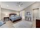 Large main bedroom with a ceiling fan, wood-look tile flooring, and en-suite bathroom at 6800 Equinox Cliff St, Las Vegas, NV 89135