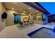 A covered patio with a ceiling fan overlooks the pool, providing a perfect spot for outdoor relaxation at 6800 Equinox Cliff St, Las Vegas, NV 89135