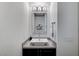 Stylish powder room with a vessel sink, decorative mirror, modern lighting, and dark wood cabinetry at 6800 Equinox Cliff St, Las Vegas, NV 89135