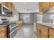 Bright kitchen featuring stainless steel appliances and wood cabinetry, offering a modern, functional space at 6953 Graceful Cloud, Henderson, NV 89011