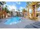 Community pool with lounge chairs and palm trees at 7139 S Durango Dr # 218, Las Vegas, NV 89113