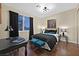 Cozy bedroom with dark wood floors, decorative pillows, and a window view at 8390 Carmel Ridge Ct, Las Vegas, NV 89113