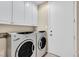 Functional laundry room with modern washer and dryer units and ample cabinet space at 8390 Carmel Ridge Ct, Las Vegas, NV 89113