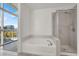 Relaxing bathroom with a soaking tub, separate shower, and large windows offering natural light at 353 E Bonneville Ave # 313, Las Vegas, NV 89101