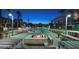 Night view of the luxurious pool area with a fire pit, ambient lighting, and comfortable seating at 353 E Bonneville Ave # 313, Las Vegas, NV 89101