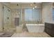 Elegant bathroom with soaking tub, walk-in shower, and modern fixtures at 10758 Chillingham Dr, Las Vegas, NV 89183