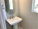 Modern powder room with pedestal sink and oval mirror at 112 Antler Square Ln, Henderson, NV 89011