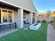 Landscaped backyard with covered patio, fire pit, and artificial turf at 32 Honeymoon Dr, Henderson, NV 89011