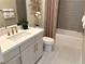 Modern bathroom with gray tile, white vanity, and gold fixtures at 32 Honeymoon Dr, Henderson, NV 89011