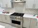 Modern gas range and stainless steel oven with geometric backsplash at 32 Honeymoon Dr, Henderson, NV 89011