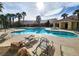 Enjoy the community pool with lounge chairs surrounded by lush palm trees at 6409 Sierra Diablo Ave, Las Vegas, NV 89130