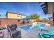 Relaxing backyard pool with sun umbrella, stylish seating, and privacy wall at 6482 Twin Harbors Ct, Las Vegas, NV 89141