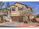 Charming two-story home with a brown garage door, neat landscaping, and a paved driveway at 6482 Twin Harbors Ct, Las Vegas, NV 89141