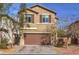 Charming two-story home with a brown garage door, neat landscaping, and a brick paved driveway at 6482 Twin Harbors Ct, Las Vegas, NV 89141