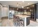 Modern kitchen with dark cabinets, stainless appliances, and granite countertop island with bar stool seating at 6482 Twin Harbors Ct, Las Vegas, NV 89141