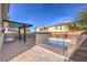 A covered patio with an outdoor grill overlooks a fenced in-ground pool with a brick surround at 6482 Twin Harbors Ct, Las Vegas, NV 89141