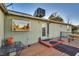 Exterior view of the backyard with a small porch, back door, and lush foliage at 7320 Bath Dr, Las Vegas, NV 89131