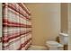 A toilet and shower with striped curtain in a neutral-toned bathroom at 7320 Bath Dr, Las Vegas, NV 89131