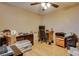 Neutral bedroom with ceiling fan, wood floor, and cluttered desk area at 7320 Bath Dr, Las Vegas, NV 89131