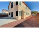 Two-story tan home featuring a concrete patio and low-maintenance rock landscaping at 3691 Springbud Dr, Las Vegas, NV 89147