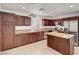 Spacious kitchen with stainless steel appliances, island, tile floors, and wooden cabinetry at 3691 Springbud Dr, Las Vegas, NV 89147