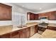 Well-lit kitchen showcasing stainless steel appliances, tile floors, granite countertops, and wooden cabinets at 3691 Springbud Dr, Las Vegas, NV 89147