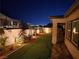 Landscaped backyard with lighting, patio, and city views at night at 144 Juliette Pointe Ln, Henderson, NV 89011