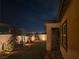 Landscaped backyard with lighting, patio, and city views at night at 144 Juliette Pointe Ln, Henderson, NV 89011