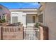 Inviting front entry with a gated patio, brick wall, and mature shrubs at 5683 Whale Watch St, Las Vegas, NV 89113