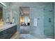 Elegant bathroom featuring marble walls, a glass shower, and modern fixtures with a view to the bedroom at 673 Falcon Cliff Ct, Henderson, NV 89012