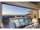 Contemporary dining area featuring a glass table with city views and an infinity pool at 673 Falcon Cliff Ct, Henderson, NV 89012