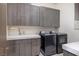 Well-organized laundry room with modern washer, dryer, sink, and plenty of cabinet space at 673 Falcon Cliff Ct, Henderson, NV 89012
