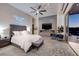 Spacious main bedroom with a plush bed, modern fireplace, and a private balcony with city views at 673 Falcon Cliff Ct, Henderson, NV 89012