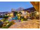 Inviting backyard with a lounge area, lush landscaping, and stone accents offer a relaxing outdoor space at 677 Boulder Summit Dr, Henderson, NV 89012