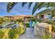 This outdoor space includes seating, lush greenery, and a built-in kitchen island at 677 Boulder Summit Dr, Henderson, NV 89012