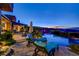 Inviting lounge area overlooks the pool and spa with rock features, landscaping, and city views at 677 Boulder Summit Dr, Henderson, NV 89012