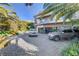 Wide driveway with two luxury cars parked in front of a home with lush, tropical landscaping at 677 Boulder Summit Dr, Henderson, NV 89012