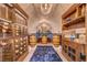 Elegant wine cellar with custom wood shelving, barrel accents, and unique lighting at 677 Boulder Summit Dr, Henderson, NV 89012