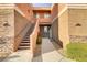 Exterior view of a condo building featuring stairs leading to the units with a landscaped walkway and stone accents at 7701 Himalayas Ave # 104, Las Vegas, NV 89128