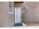 Unit #104 front door with white exterior, textured stucco wall, and a secure entrance enhancing curb appeal at 7701 Himalayas Ave # 104, Las Vegas, NV 89128