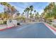 View of the community's gated entrance surrounded by mature palm trees and lush landscaping with an inviting entry at 7701 Himalayas Ave # 104, Las Vegas, NV 89128