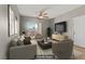 Comfortable living room features a ceiling fan, TV, and sliding glass door to a balcony at 7701 Himalayas Ave # 104, Las Vegas, NV 89128