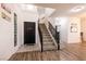 Bright foyer featuring a staircase with black railings and wood flooring at 7936 Dexter Falls St, Las Vegas, NV 89149