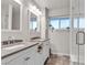 Bright bathroom featuring double sinks, granite counters, and a glass enclosed shower at 260 E Desert Rose Dr, Henderson, NV 89015