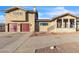 Two-story house showcasing a dual-car garage, desert landscaping, and a paved driveway at 260 E Desert Rose Dr, Henderson, NV 89015