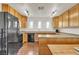 Bright kitchen with wood cabinets, black appliances and wood-look floors at 260 E Desert Rose Dr, Henderson, NV 89015