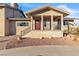 House porch with a red door, desert landscaping, a brick paved driveway, and black metal porch railings at 260 E Desert Rose Dr, Henderson, NV 89015